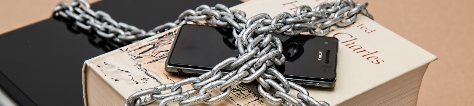 a mobile phone chained to a book